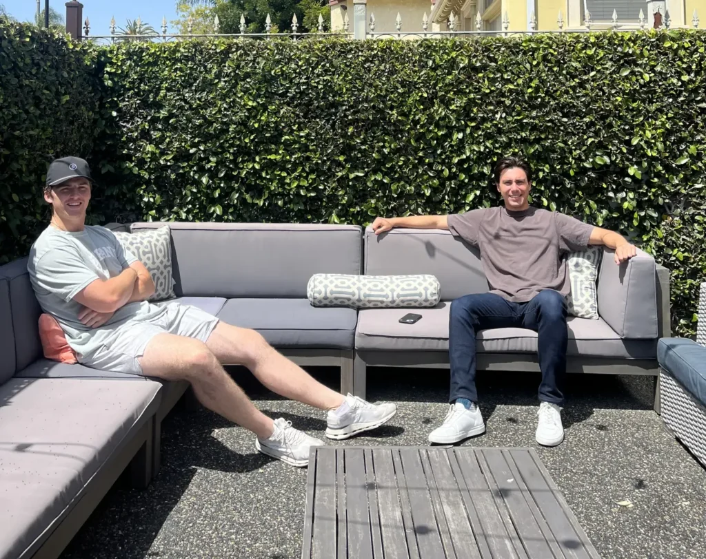 two friends sitting on outdoor couches at The Hive Ellendale - USC student housing